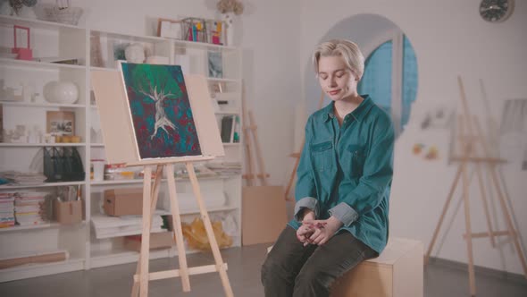 A Young Woman Artist Sitting in the Art Studio After Finishing the Painting