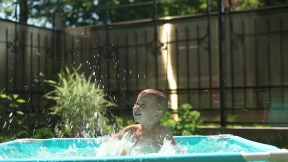 Caucasian Baby Child Kid Boy Having Fun in Pool in Backyard Outdoors Sunny Day