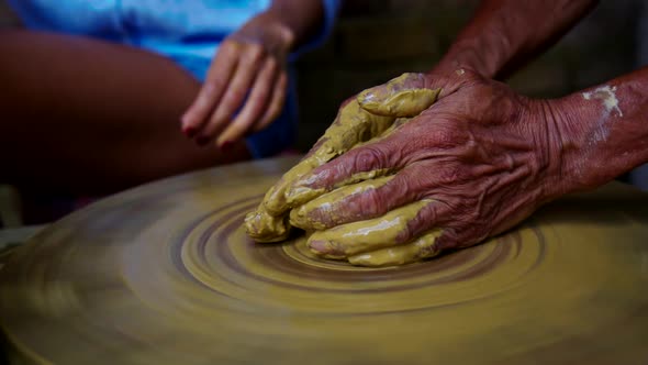 Senior Potter Starts Making Clay Pot on Wheel Girl Continues