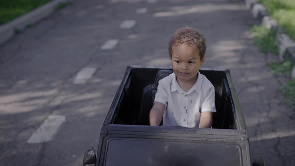 Cute African American Boy in a Toy Car