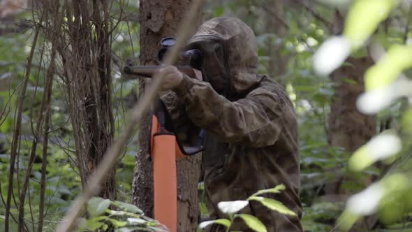 Hunter in Camouflage Clothes Takes Aim While Standing From Hunting Rifle. Man in Comfortable