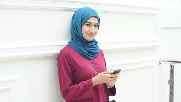 Muslim Girl in Hijab Uses Smartphone for Online Shopping