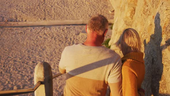 Senior couple walking alongside beach