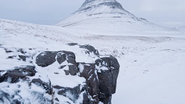 Drone Over Waterfall In Snow Towards Kirkjufell Mountain