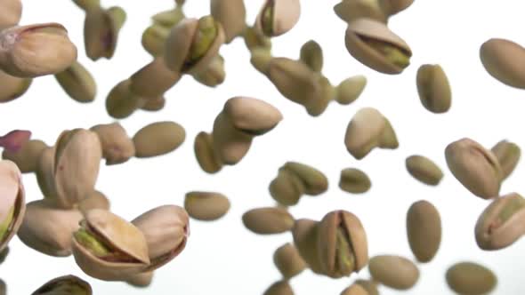 Closeup of Salted Pistachios Falling Down on a White Background