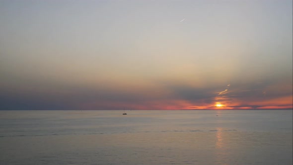 Time Lapse Sunset on the Adriatic Sea. Several Boats Sail Through the Calm Evening Sea