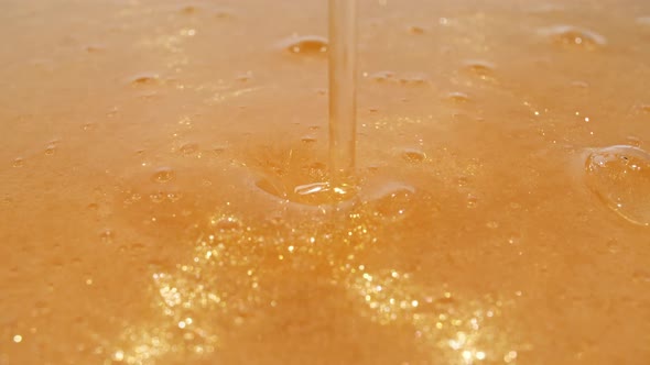 Slow Motion Shot of Pouring Oil Liquid Yellow Golden Hue