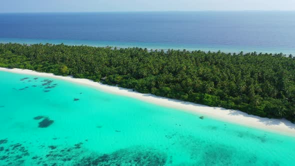 Wide overhead island view of a white sandy paradise beach and blue sea background 