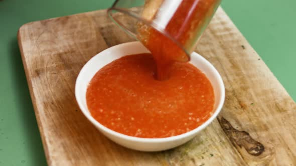 Hand dipping Tortillas chips in salsa sauce