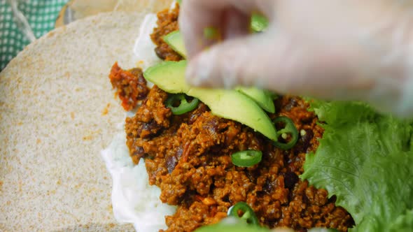 The Chef Arranges the Avocado Slides Over the Burrito