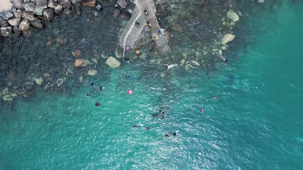 Aerial view of people enjoying a mix of different water activities. High drone view