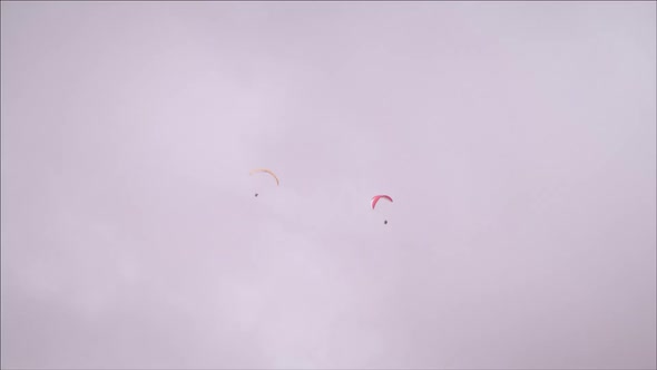 Long distance shot of two paragliders spinning closely to each other in Switzerland