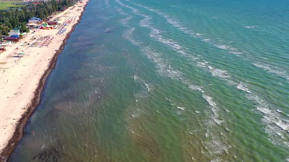 Beautiful flight in summer over the beach. People are resting near the sea.