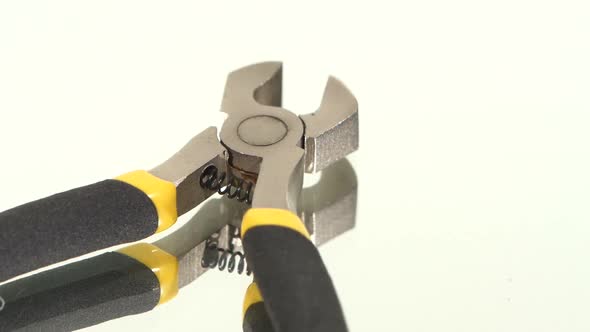 Part of Wire Cutters with Yellow, Gray Handle on White, Reflection, Rotation
