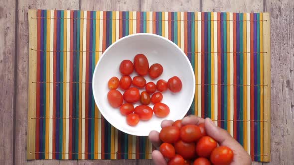 Falling Red Color Cherry Tomato in a Bowl on Table