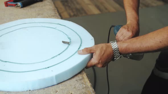 Closeup Hand Male Worker Cutting Foam Rubber for the Production of a Sofa in a Furniture Factory