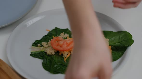 Close-up of Female hands make veggie wrap with quinoa and vegetables