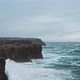 Drone moves above wild waves crashing into ocean coastal cliffs - VideoHive Item for Sale