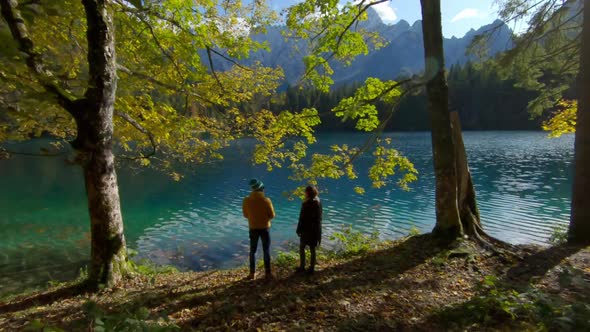 Couple standing at lakeside, Parco Naturale dei Laghi di Fusine, Italy