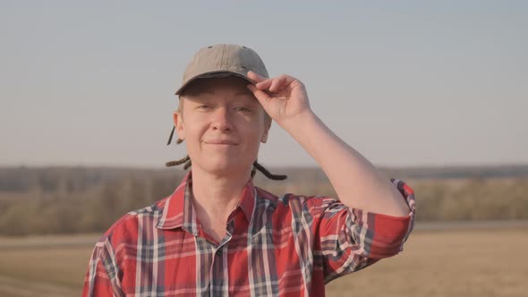 Portrait of contented farmer standing in field looking at camera