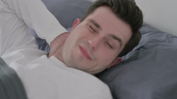 Man Having Neck Pain While Sleeping in Bed Close Up