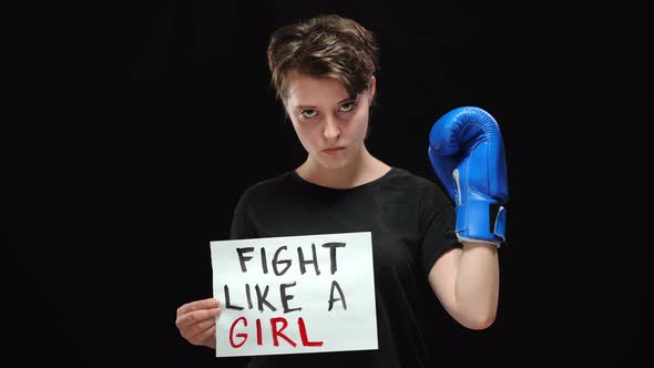 Confident Serious Woman in Boxing Glove Holding Fight Like a Girl Sign Looking at Camera