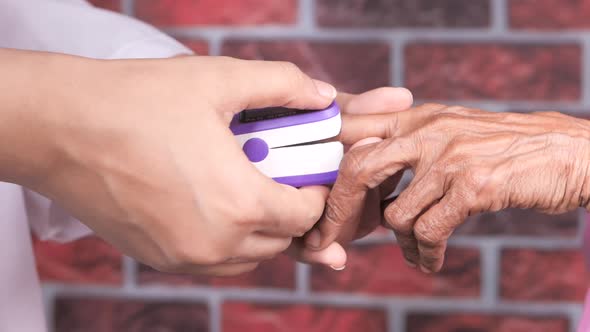 Senior Women Hand Using Pulse Oximeter