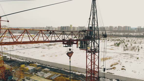 High Rusty Construction Cranes on Building Site By Wasteland