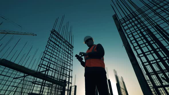 An Engineer Checks Construction Site with Reinforcement.