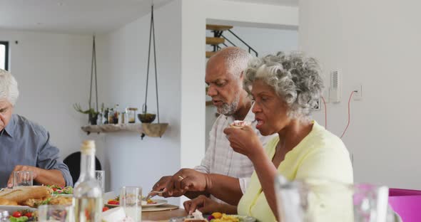 Happy senior diverse people having dinner at retirement home