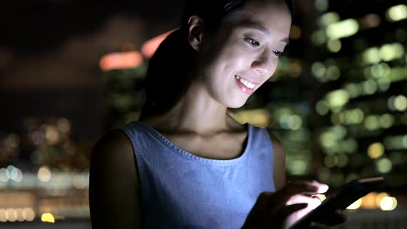 Woman using mobile phone in city 