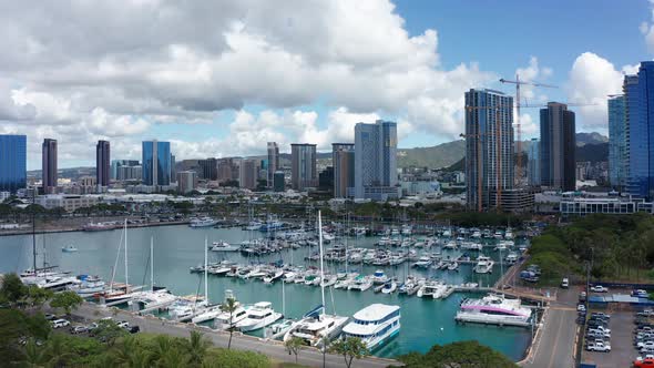 Aerial reverse pullback shot of a boat marina in downtown Honolulu, Hawaii. 4K