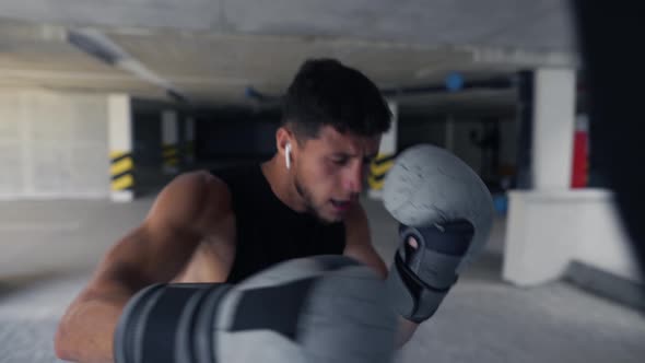 The Man Executes Strong Blows in the Boxing Bag Accelerate Speed Footage