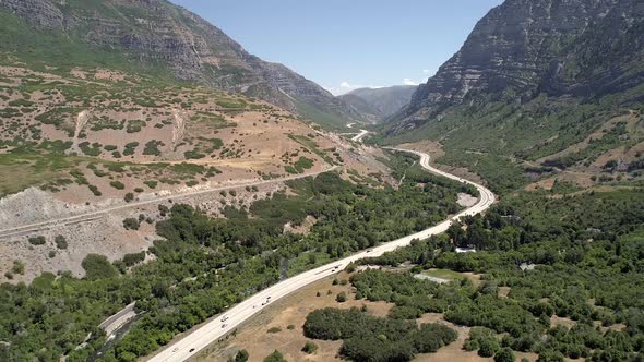 Flying backwards over winding roads through canyon