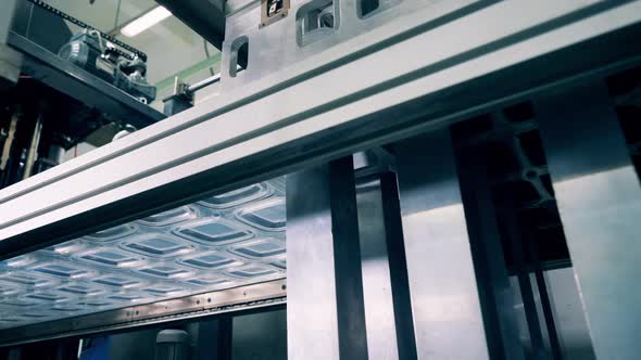 Machine Squeezing Tray Lids Out of the Plastic Sheet and Stacking Them