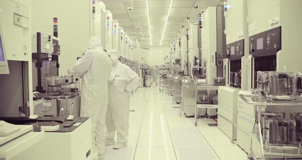 Workers in clean suits in a Semiconductor manufacturing facility