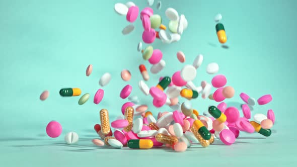 Super Slow Motion Shot of Falling Colorful Pills on Light Green Background at 1000Fps