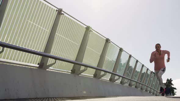 Sporty Caucasian woman exercising outdoor on a bridge