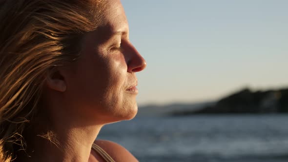 Caucasian woman enjoying by the sea before sunset  4K 2160p 30fps UltraHD footage - Close-up of blon