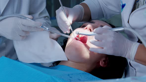 A Dentist is Doing an Oral Examination of His Young Woman Patient