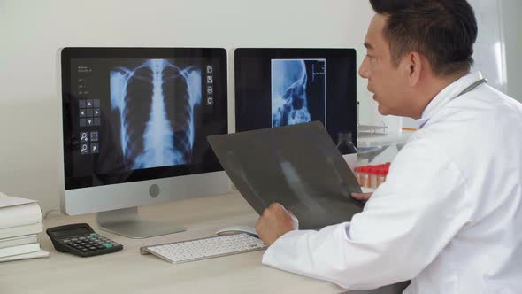 Male Doctor Studying X-ray Pictures