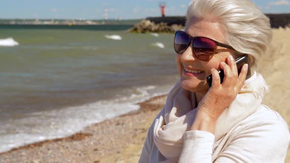 Senior Woman Calling on Smartphone on Summer Beach