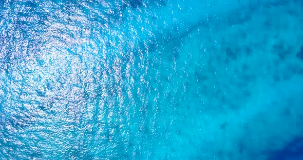 Luxury overhead abstract shot of a sandy white paradise beach and aqua blue water background in colo