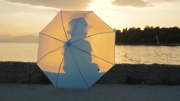 Cheerful Boy of 5-6 Yearls Old Walks Along Coastline with Umbrella in His Hands. Portrait of Happy