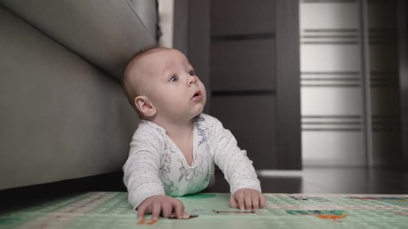 Joyful Baby Crawls on the Mat and Smiles