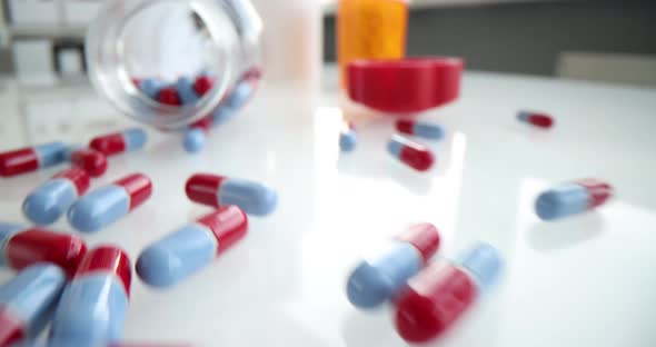 Scattered Bluered Medical Pills on Table Closeup