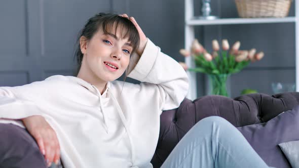 Medium Shot Portrait Smiling Young Handsome Female Sitting Leaning Back on Couch