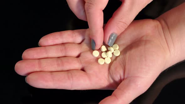 Handful of Pills in the Hand of the Girl Closeup