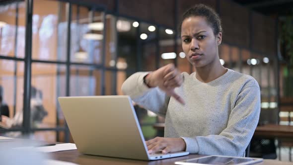 Thumbs Down By African Woman Working on Laptop