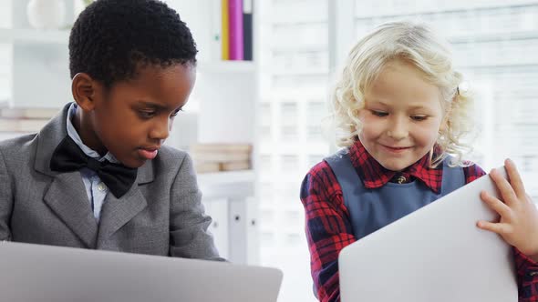 Kids as business executives discussing over laptop 4k